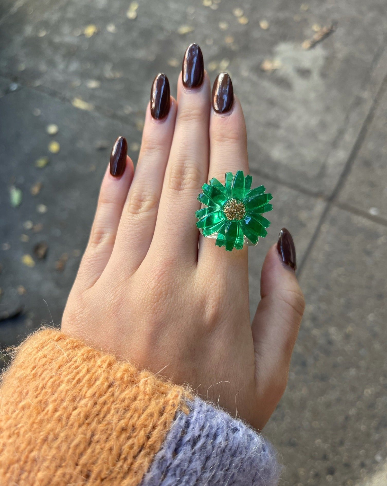 A close up of a hand wearing a green version of ring.
