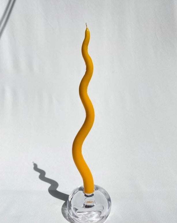 candle stick placed in spherical holder against white backdrop